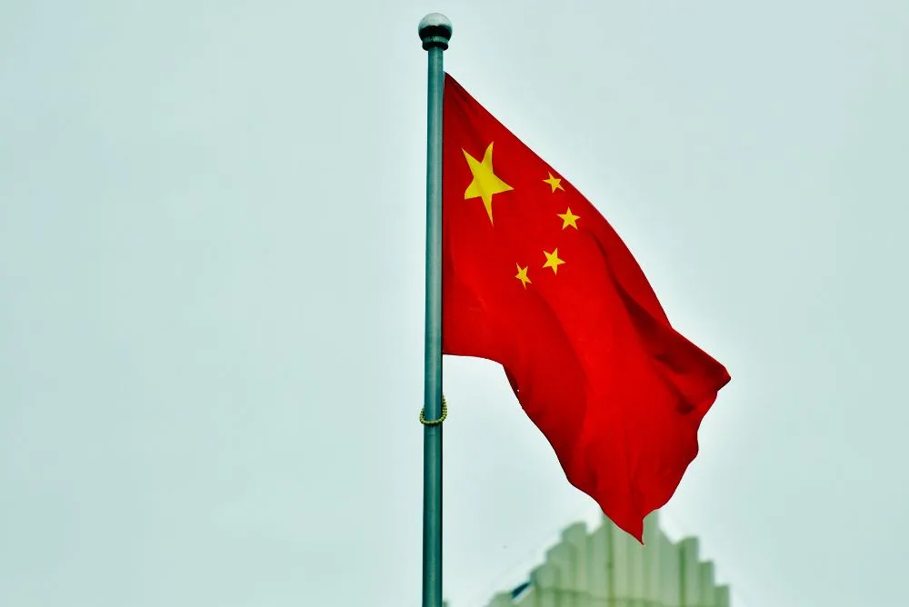 The flag of China flying against a pale sky