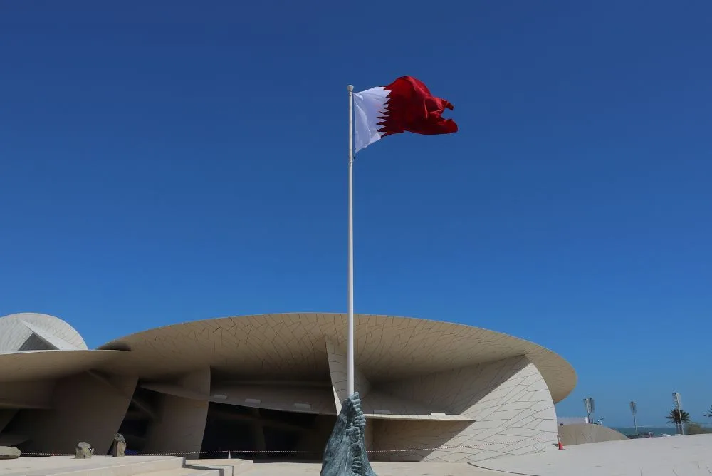 The Qatari flag beside the National Museum of Qatar in Doha