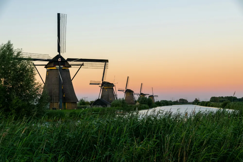 A row of windmills at Kinderdijk in the Netherlands at sunset