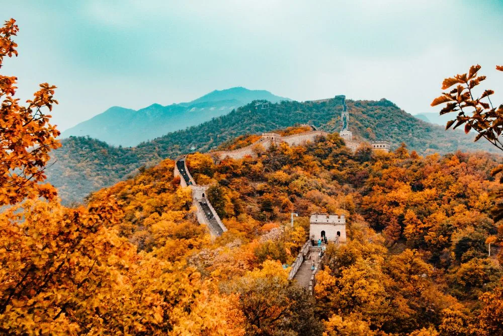 The Great Wall of China winding along a ridge through autumn hills