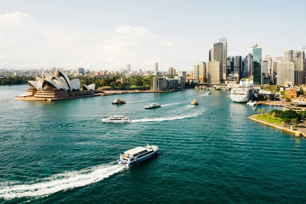 Sydney Opera House on the harbour with the city skyline behind it