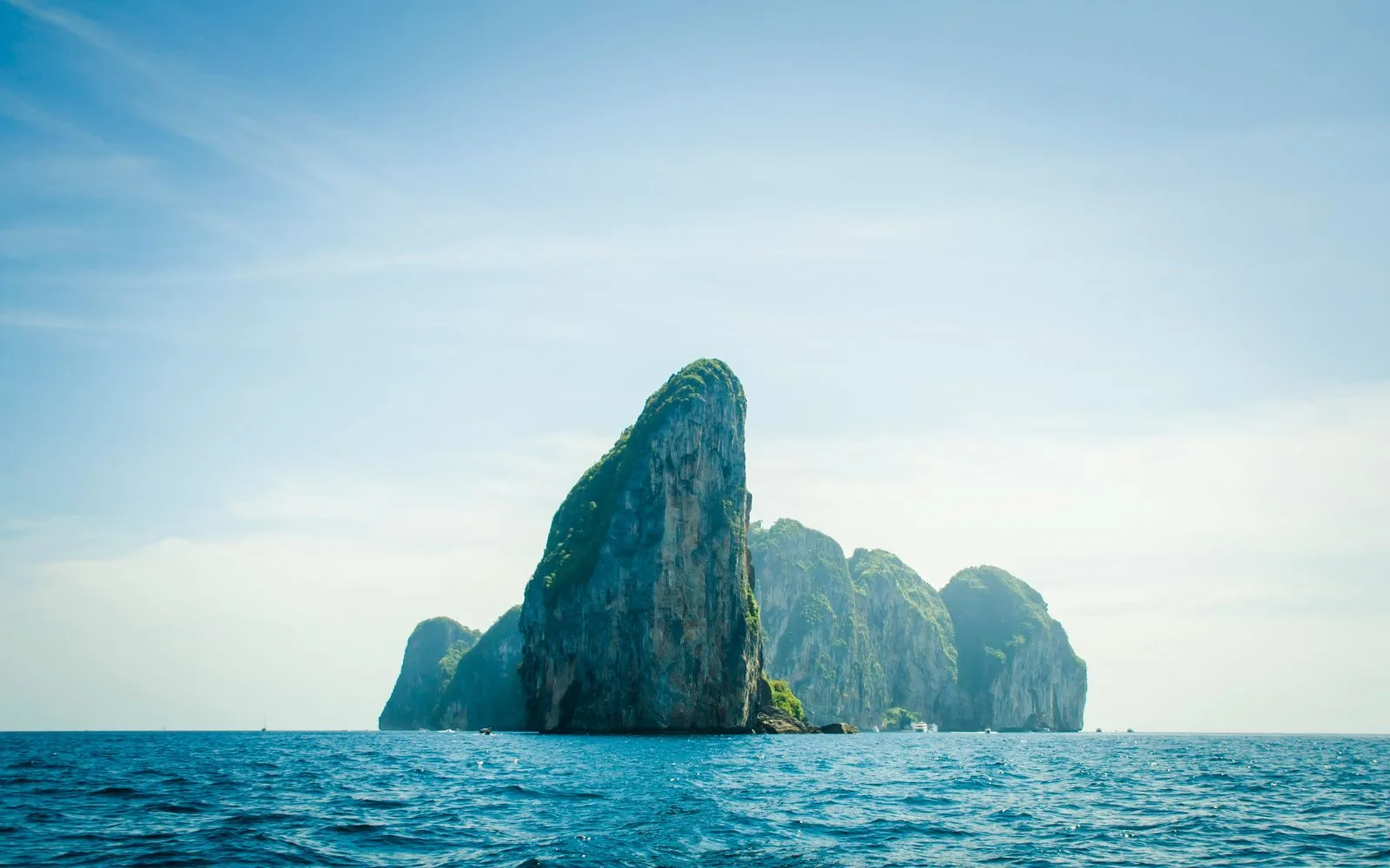 A limestone sea stack rising from calm blue water