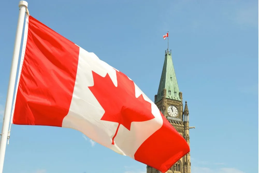 The Canadian flag flying beside the Peace Tower on Parliament Hill in Ottawa