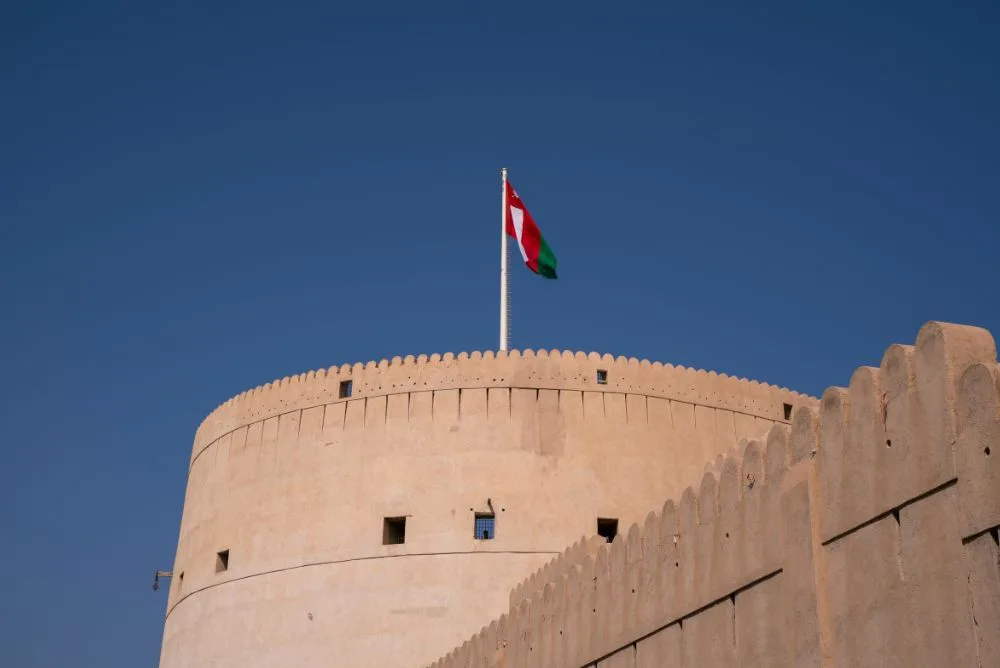 The Omani flag flying above the round tower of Nizwa Fort