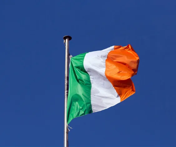 The Irish tricolour flying against a blue sky